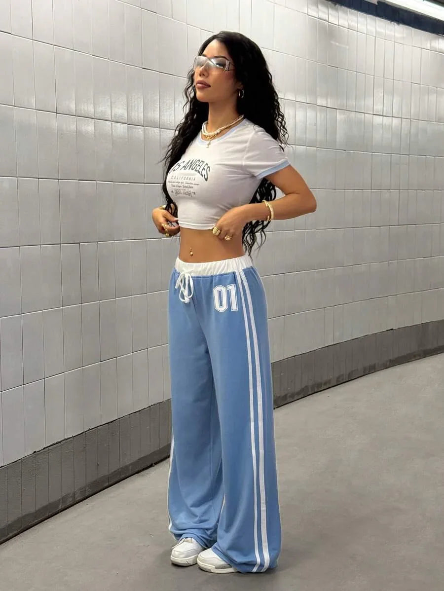 Woman wearing HUSTLE801 01 Baggy Sweatpants in light blue cotton with white stripes and drawstring waist