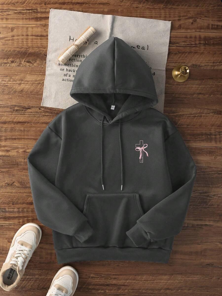 Charcoal cotton hoodie with pink bow cross embroidery, front pocket, laid flat with sneakers