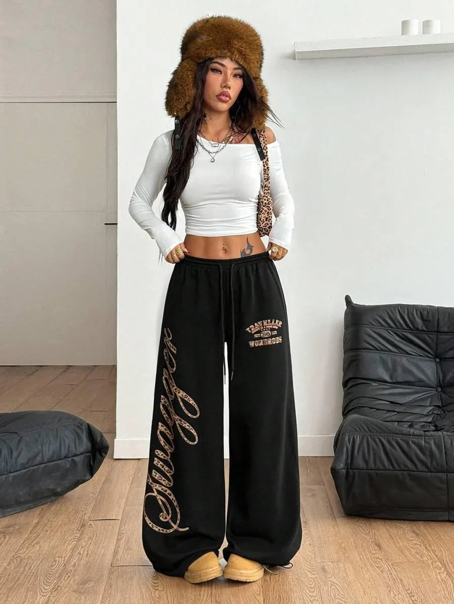 Woman in white crop top and black cotton Swaggy pants with leopard print, brown faux fur hat, HUSTLE801