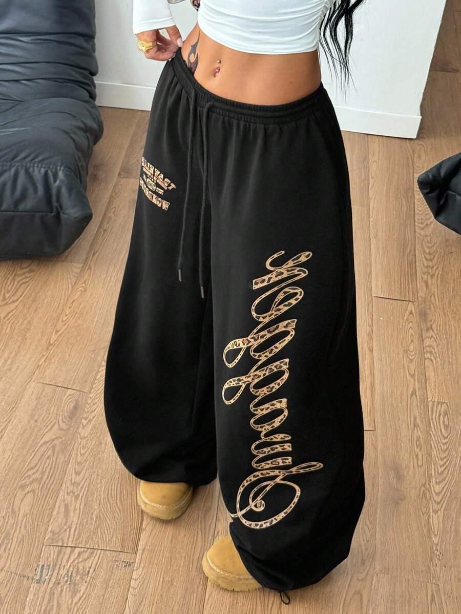 Black cotton HUSTLE801 Chosen baggy sweatpants with leopard print lettering, cozy and on-trend.