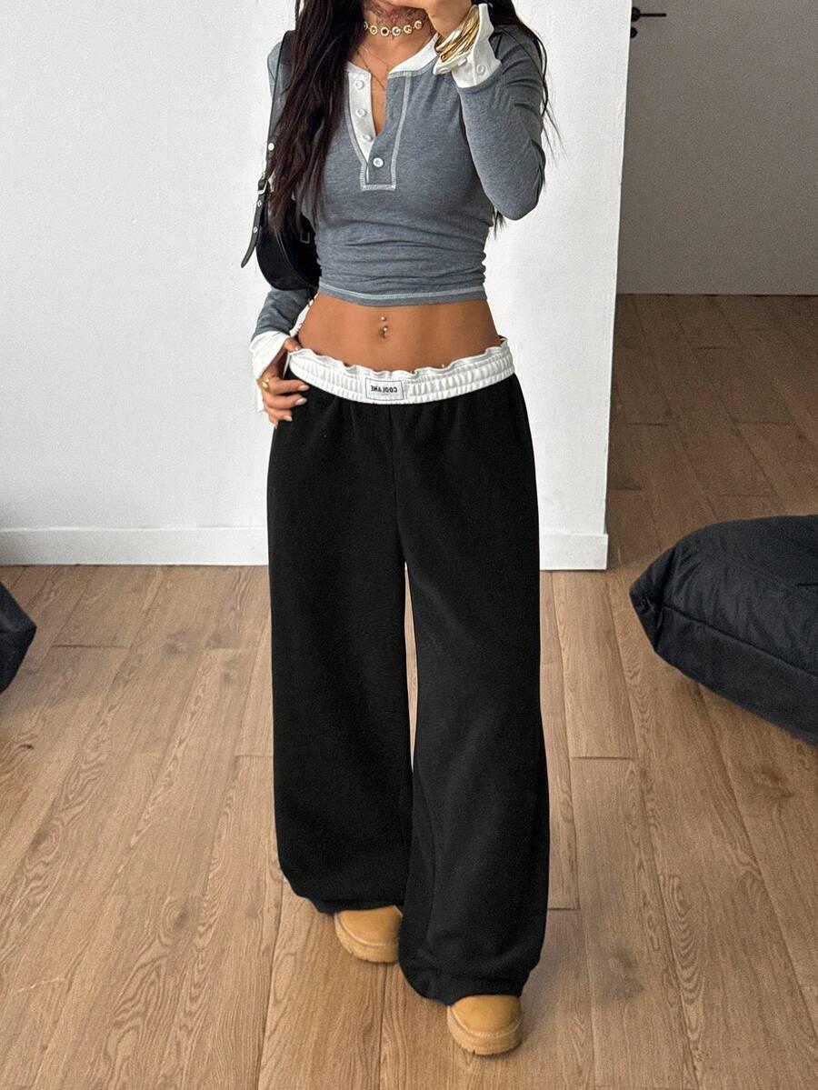 Baggy black cotton pants with white elastic waistband from HUSTLE801 on a wood floor