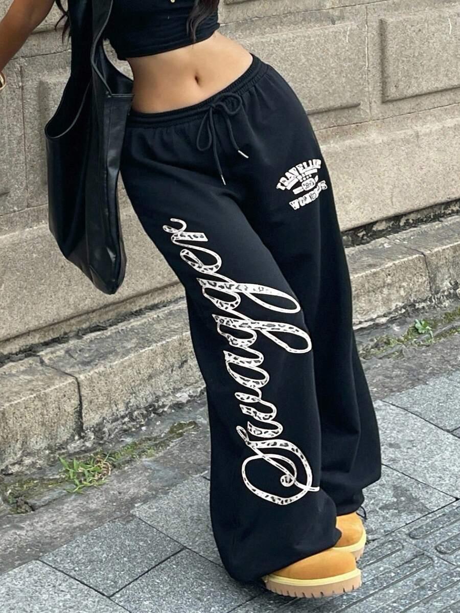 Savage black cotton sweatpants with bold white print, streetwear style, relaxed fit