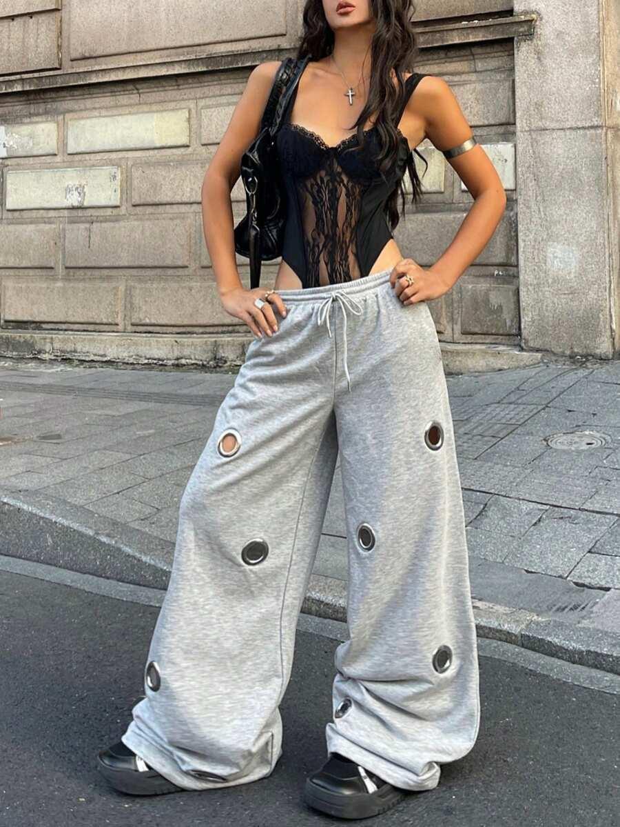 Woman wearing black lace bodysuit and HUSTLE801 gray cotton baggy grommet sweatpants on street