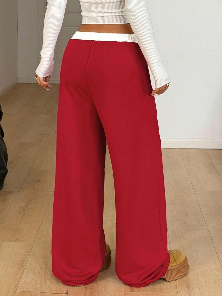 Red wide-leg cotton sweatpants with white elastic waistband, baggy fit, model standing indoors