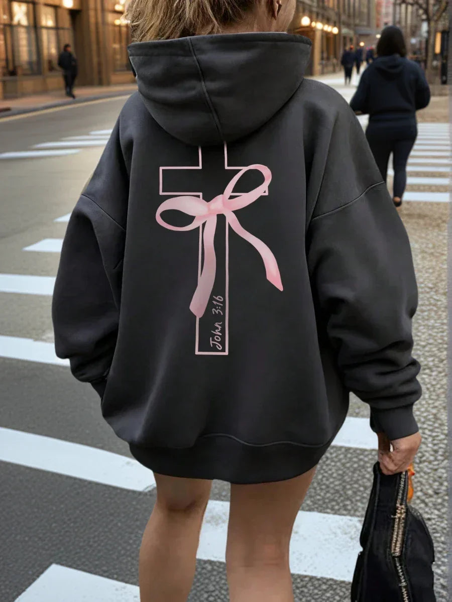 Oversized black cotton hoodie with pink cross and ribbon graphic, John 3:16 text on back