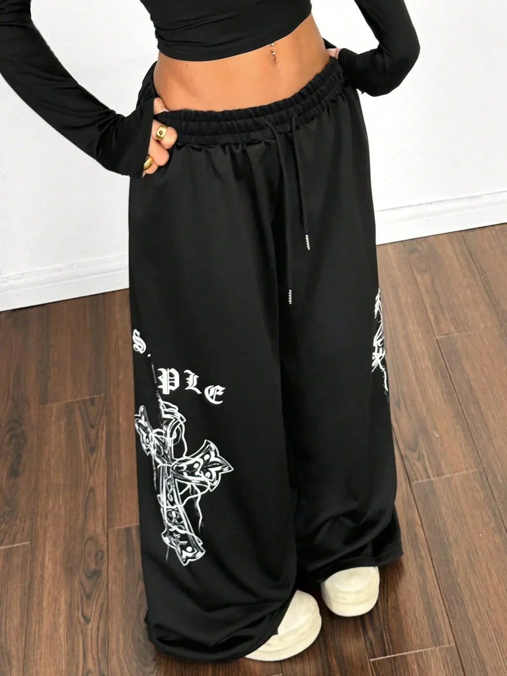 Black cotton baggy pants with white cross graphic by HUSTLE801, paired with crop top