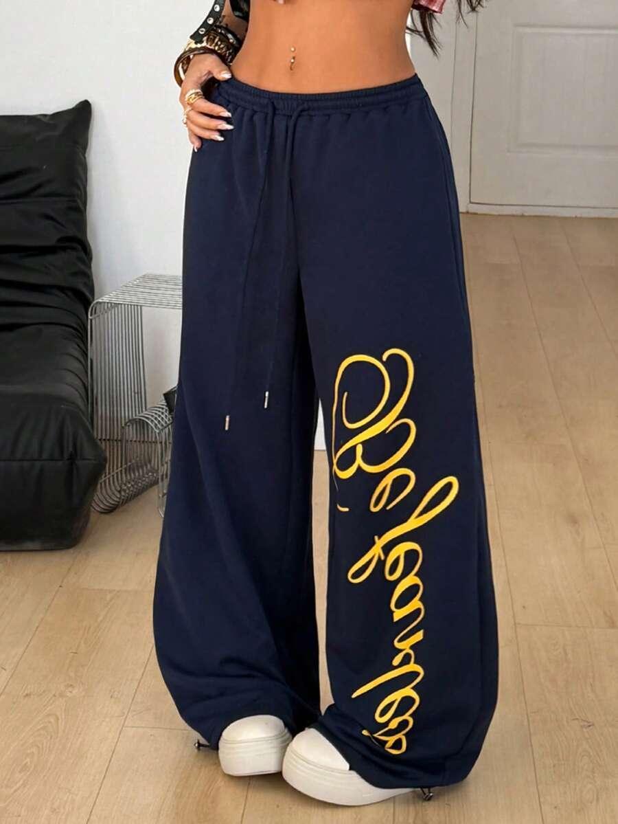 Navy blue cotton baggy sweatpants with yellow script, Be Famous, elastic waistband, streetwear style