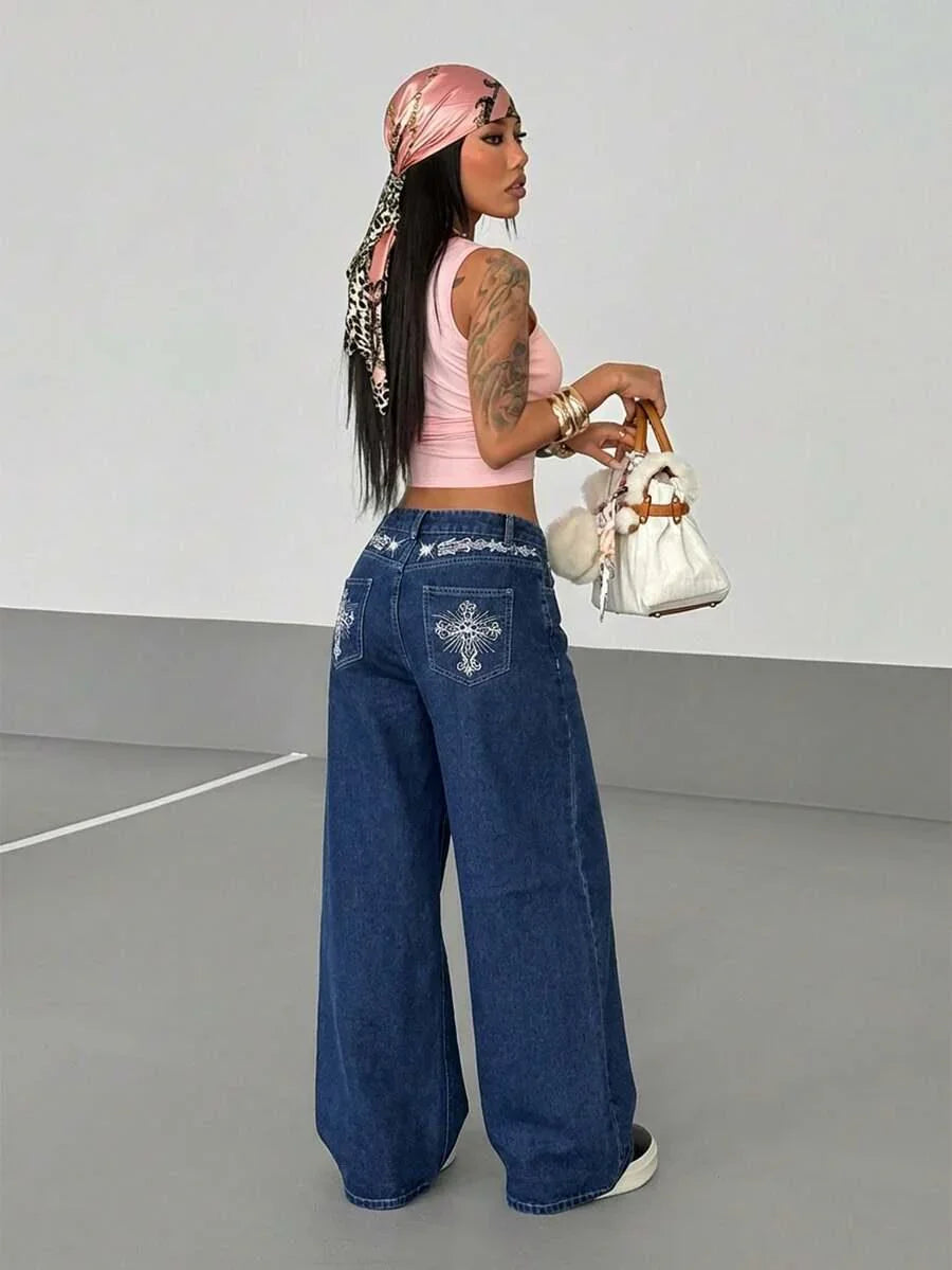Woman in pink tank top and blue denim HUSTLE801 baggy jeans, holding white faux fur purse