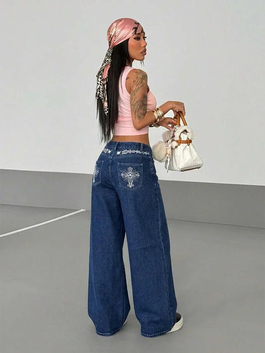 Woman in pink tank top and blue denim HUSTLE801 baggy jeans, holding white faux fur purse