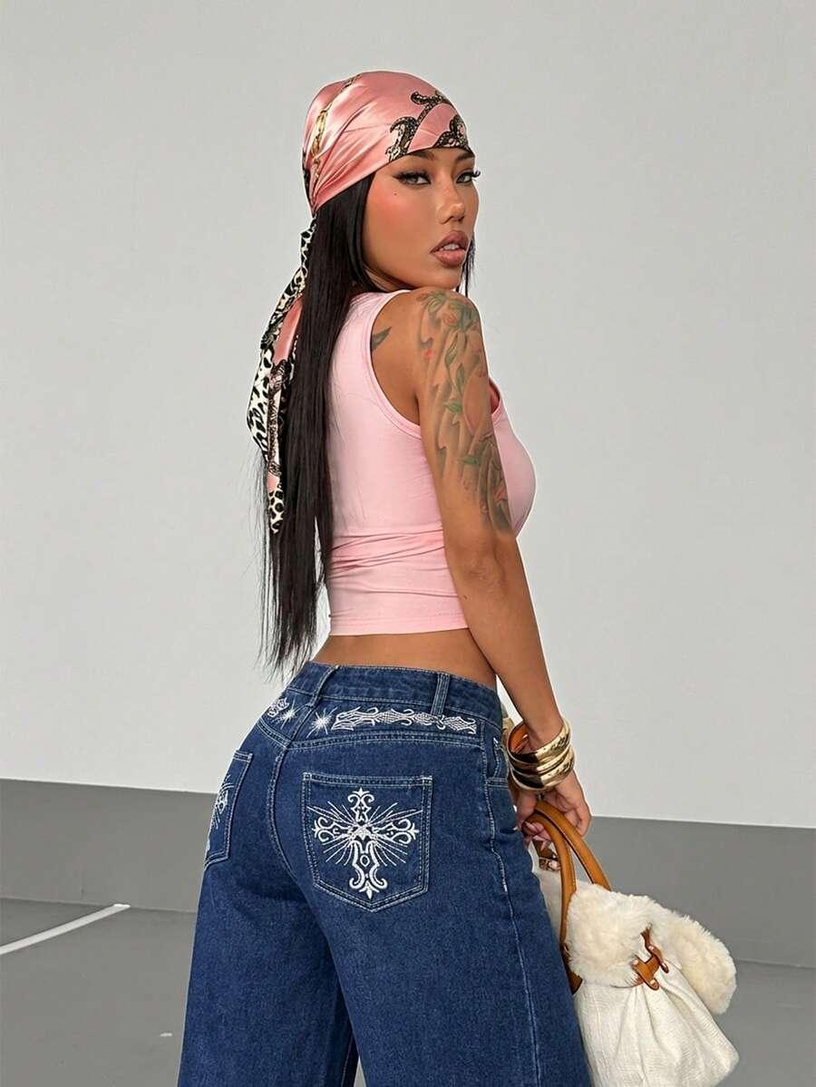 Woman in pink satin bandana, pink cotton tank top, denim embroidered baggy jeans, faux shearling bag